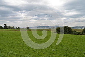 Green Meadow on the banks of Zurich River, Cloudy Sky, Buildings on other bank