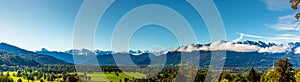 Green meadow field, snow covered mountain range. European Alps at bad toelz Brauneck. Isartal Valley photo