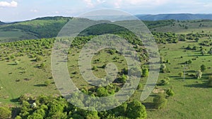 Green meadow in the spring, countryside hills from above, aerial view