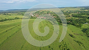 Green meadow in the spring, countryside hills from above, aerial view