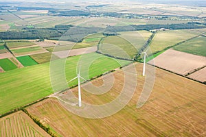 Green meadow with wind turbines generating electricity, summer landscape, alternative energy sources