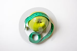 Green measuring tape over green apple. Diet and Healthy life, loss weight concept. Top view. Isolated. White background