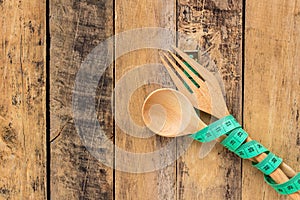 Green measuring tape and wooden spoon and fork