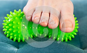 Green medical device for foot massage. Home physiotherapy. Close-up