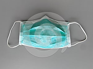 Green Medical mask to protect from bacteria, virus, sneeze, cough, and pollution on gray background