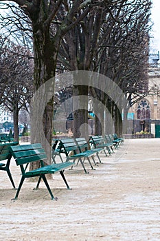 Green metal chairs in the garden in winter season