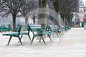 Green metal chairs in the garden in winter season