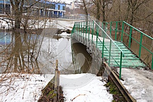 Green metal footbridge, flood on the Bitsa river, fast current, spring 2021, background