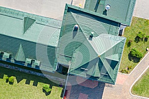 Green metal house roof with installed ventilation pipes. aerial view