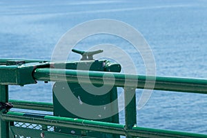 Green metal rope tie down on the deck area of a ferry