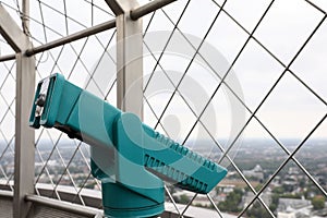 Green metal tower viewer on observation deck. Space for text