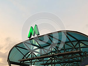Green metro sign on the visor of entrance