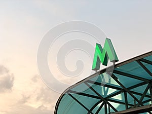 Green metro sign on the visor of entrance