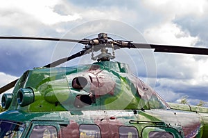 Green military helicopter blades on blue sky background.