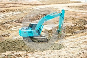 Green mini Crawler excavator hydraulics digging a hole concrete and hard rock