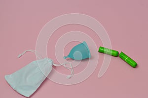 Green mint color menstrual cup and feminine hygiene tampons on white color background. female intimate hygiene period products.