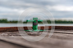 Green mooring handle on the old wooden pier