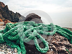 The green mooring line lies on the rocks