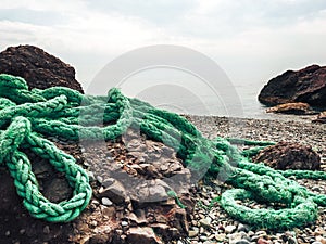 The green mooring line lies on the rocks