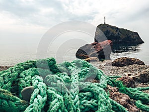 The green mooring line lies on the rocks