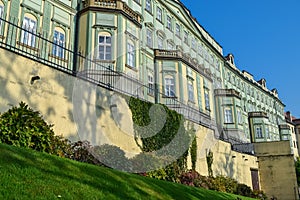 Green moss on an old fence with an ancient building under the sun