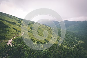 Green mountain landscape covered with clouds - vintage film effe