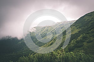 Green mountain landscape covered with clouds - vintage film effe