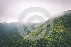 Green mountain landscape covered with clouds - vintage film effe