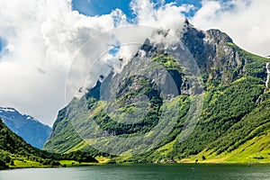 Green mountain peak above the small village in Naeroy fjord,  Aurlan, Sogn og Fjordane county, Norway