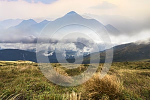 Green mountains panoramic view on blue sky with white clouds copy space background on bright sunny day. Tourism and traveling