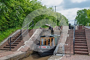 Green Narrowboat leaves a lock chamber