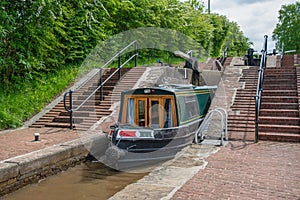 Green Narrowboat leaves a lock chamber