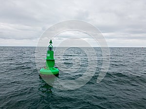 Green Navigational buoy in sea with clouds slow motion