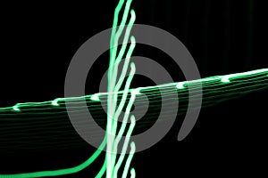 Green neon light lines and curves abstract image on black background