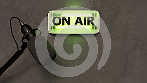 Green neon sign with the word ON AIR and studio microphone