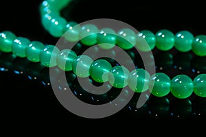 Green nephritis beads isolated on black background photo