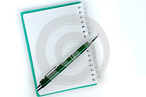 Green notebook with lined pages and a pen