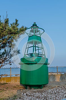 Green ocean buoy on display in maritime park