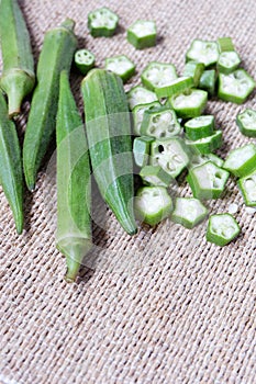 Green okra or okro or Ladyfingers on wooden fiber tablecloth