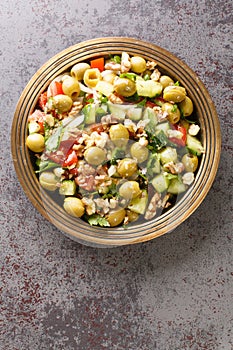 Green olive salad yesil zeytin salatasi with vegetables closeup on the plate. Vertical top view