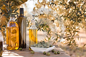 Green olives and oil on table in olive grove