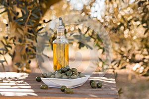 Green olives and oil on table in olive grove