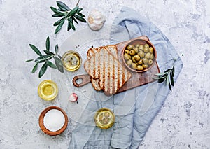 Green olives, olive oil and ciabatta bread.