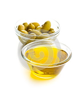 Green olives and olive oil in glass bowl