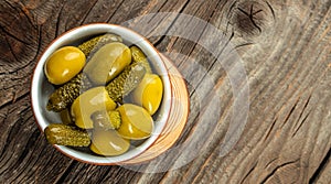 Green olives stuffed with cucumbers on a wooden background. Long banner format. top view. copy space for text
