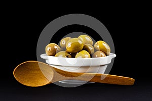 Green olives in a white bowl.