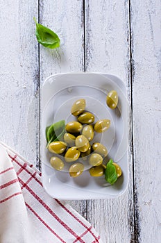 Green olives on a white plate