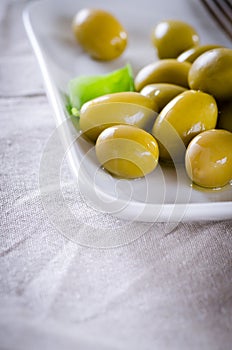 Green olives on a white plate