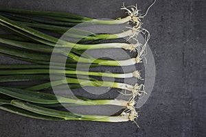 Green onion on dark grey table flat lay