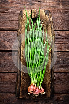 Green onion or scallion on wooden board, fresh spring chives